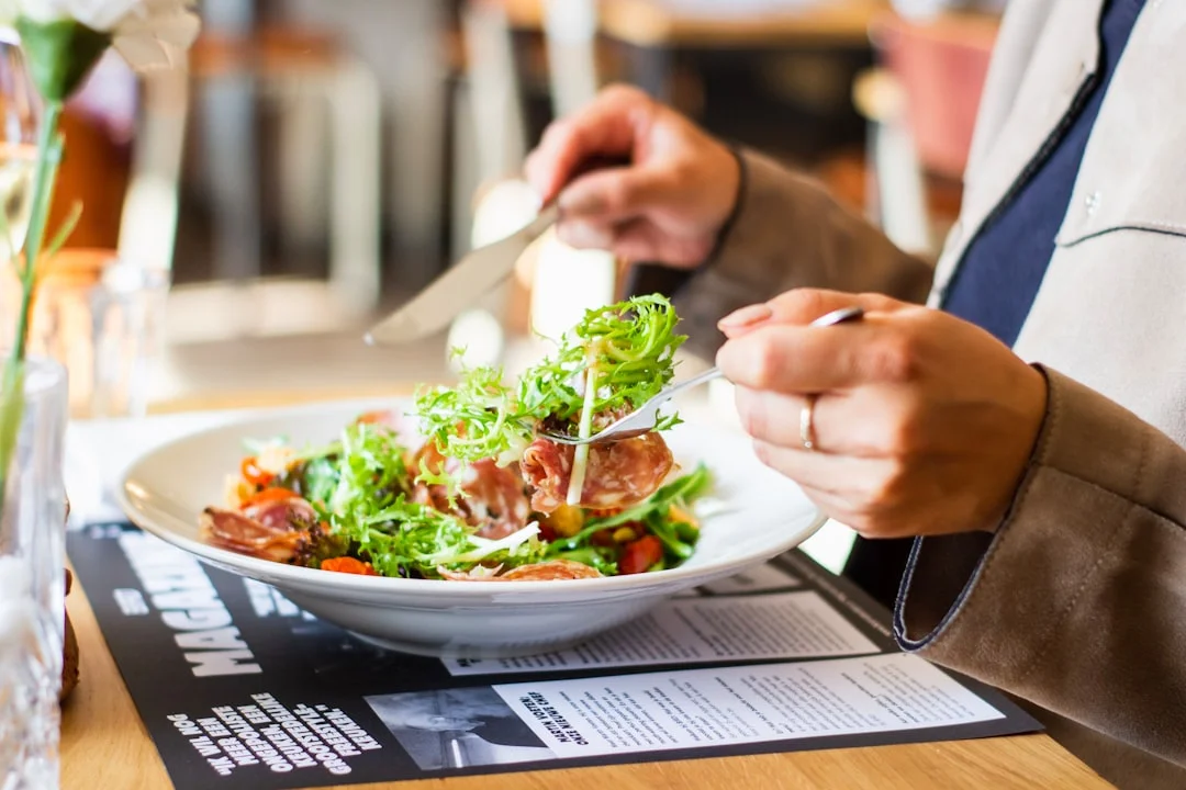 Mão de chef ajustando o preço de um prato em um restaurante, com foco em precificação de pratos.